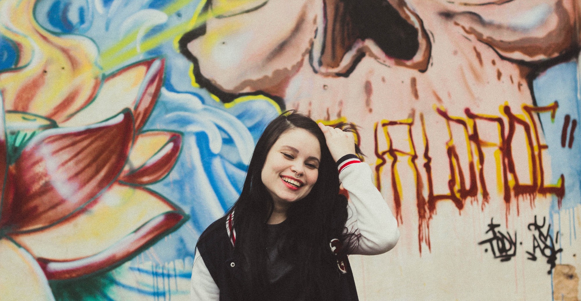 Girl in front of wall with graffiti
